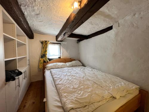 een kleine slaapkamer met een bed en een raam bij Ferienhaus Gemütliche Stube in Überlingen