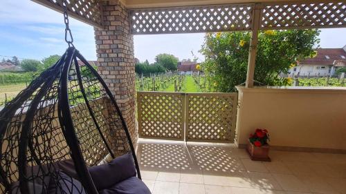 a hammock on a patio with a view of a field at Lugas Apartman in Villány