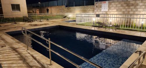 a swimming pool with a bench in a building at Flat na Av. Fernando Côrrea in Cuiabá