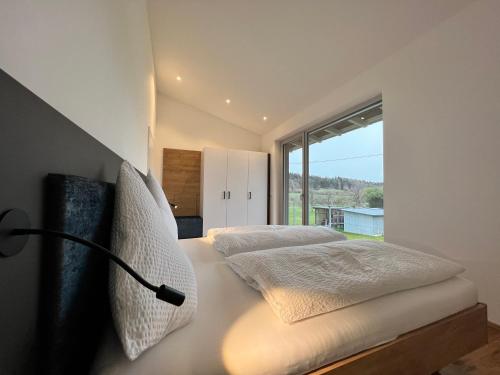 1 dormitorio con 1 cama y ventana grande en Landhaus zum See - Fewo Birke, en Überlingen