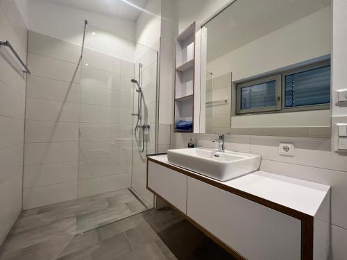 a white bathroom with a sink and a shower at Landhaus zum See - Fewo Birke in Überlingen