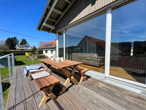 a wooden picnic table on the deck of a house at Landhaus zum See - Fewo Eiche in Überlingen