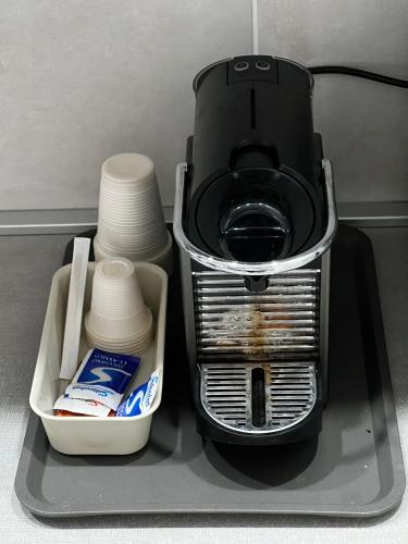 a coffee maker with a container of milk and cups at Love4Rome Guest House in Rome