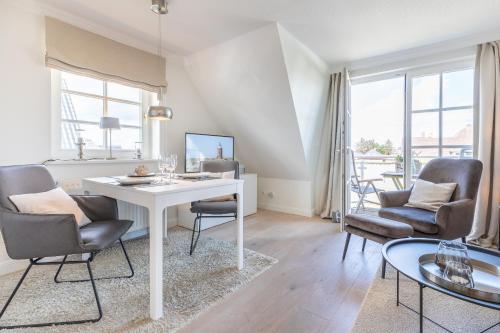 ein Wohnzimmer mit einem weißen Tisch und Stühlen in der Unterkunft Hingst, App. 3 Nettes Neest in Wenningstedt-Braderup