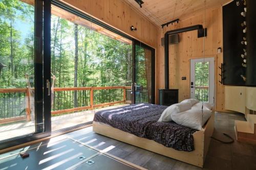 una camera da letto in una casa sull'albero con una grande finestra di Cabin Zoobox 78 a Eastman