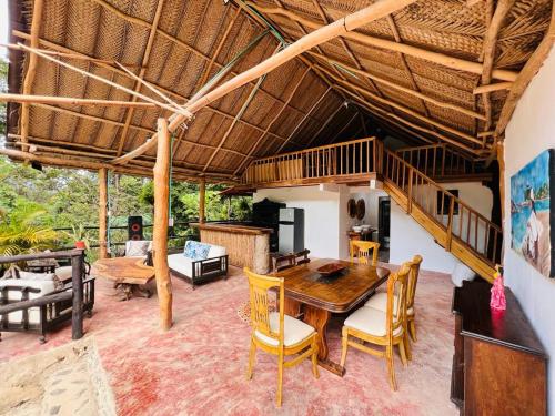 ein Esszimmer mit einem Holztisch und Stühlen in der Unterkunft Cabaña la roca de minca sierra nevada in Santa Marta