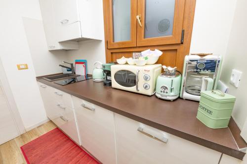 a kitchen counter with a microwave and appliances on it at Isa Sweet Home in Venice