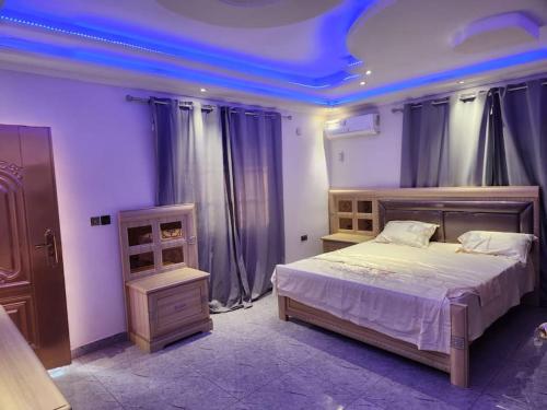 a bedroom with a large bed with a blue ceiling at Medi Square Lodge in Freetown