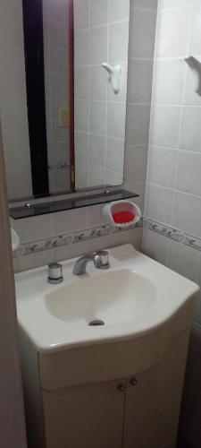 y baño con lavabo y espejo. en Departamento con quincho h/5 huéspedes en La Paz