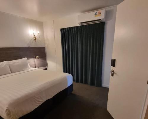 a hotel room with a bed and a window at Lakeview Colonial House in Queenstown