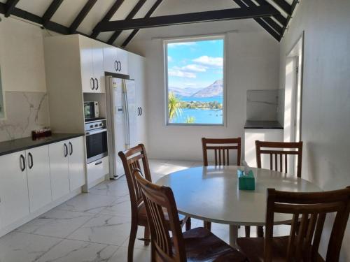 a kitchen with a table and chairs and a window at Lakeview Colonial House in Queenstown
