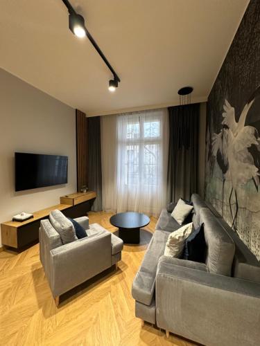 a living room with two couches and a flat screen tv at Apartamenty Sebastiana in Kraków