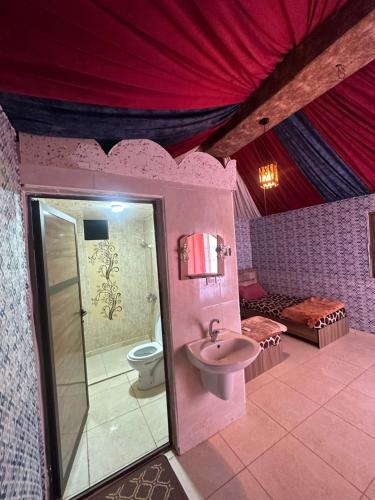 a pink bathroom with a toilet and a sink at Dream Bedouin life camp in Wadi Rum