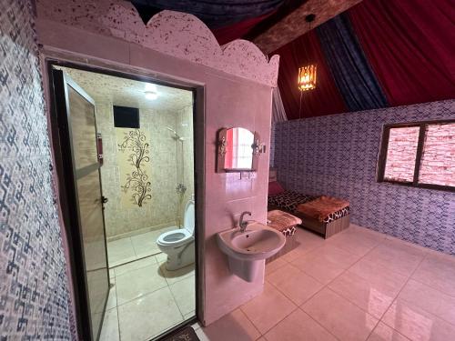 a pink bathroom with a toilet and a sink at Dream Bedouin life camp in Wadi Rum