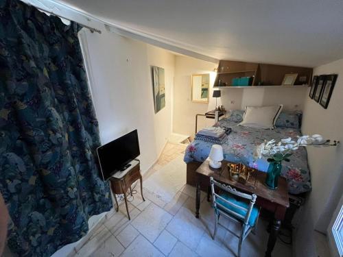 une chambre avec un lit et un bureau avec une télévision dans l'établissement Maison de 6 pièces au coeur du village d'Eze, à Èze