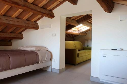 um quarto com uma cama e um sofá em Iris House em Chioggia
