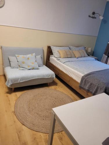1 Schlafzimmer mit 2 Betten, einem Tisch und einem Teppich in der Unterkunft Gästehaus Kampik in Witten