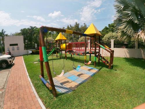 un parque infantil con columpios en el césped en VP Casa Condominio con Aire Acon, en Neiva