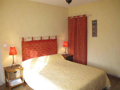 アゴン・クタンヴィルにあるMaison d'une chambre a Agon Coutainville a 800 m de la plage avec terrasse et wifiのベッドルーム1室(赤いカーテンとランプ2つ付)