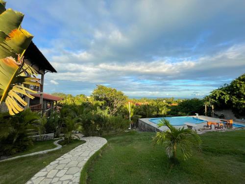 a house with a yard with a swimming pool at Pipa Golfinhos Pousada in Pipa