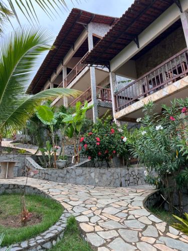 a house with a stone walkway in front of it at Pipa Golfinhos Pousada in Pipa