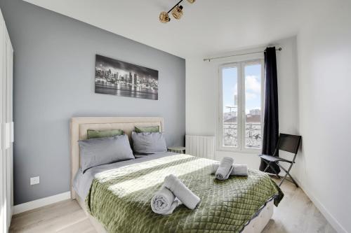 une chambre avec un lit avec deux serviettes dessus dans l'établissement Appartement Suite 41 aux Portes de Paris, à Aubervilliers
