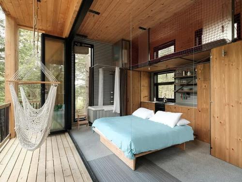 ein Schlafzimmer mit einem Bett und einer Hängematte auf einer Terrasse in der Unterkunft Cabin Zoobox 81 in Eastman