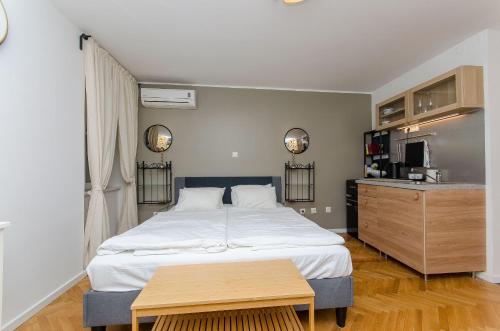 a bedroom with a large bed and a kitchen at Apartments Urban in Split