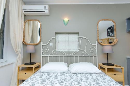 a bedroom with a bed and two mirrors on the wall at Apartments Urban in Split