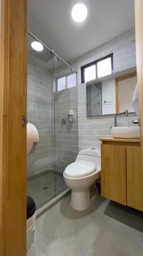 a bathroom with a toilet and a glass shower at Edificio Helena in Medellín