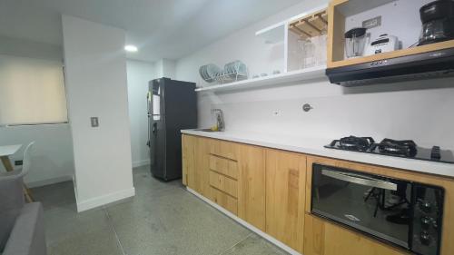 a kitchen with a black refrigerator and a microwave at Edificio Helena in Medellín