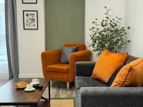 Modern One-Bedroom Apartment في سويندون: غرفة معيشة مع أريكة وكرسي