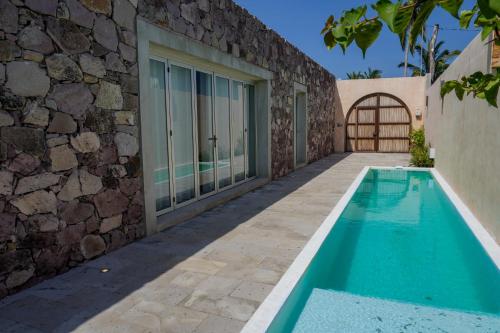 una casa con piscina accanto a un muro di pietra di Villa Quetzalpapalotl a Pérula