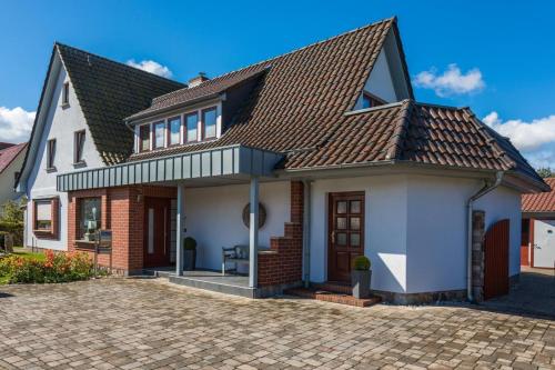 une maison blanche avec un toit marron dans l'établissement Ostseeliebe, gemütliche und moderne Ferienwohnung für 2 Personen in Zingst, à Zingst