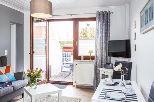 a living room with a couch and a table at Ostseeliebe, gemütliche und moderne Ferienwohnung für 2 Personen in Zingst in Zingst