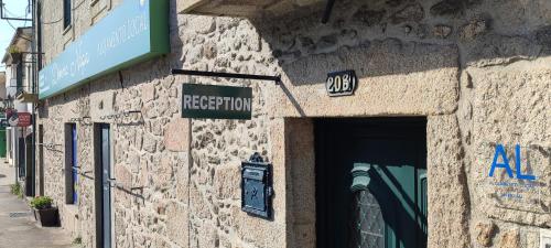 un edificio de piedra con un letrero en la calle en Donna Nega Alojamento Local, en Caminha