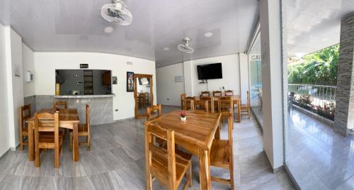 une salle à manger avec des tables et des chaises en bois dans l'établissement HOSTAL LAS FLORES, à Capurganá