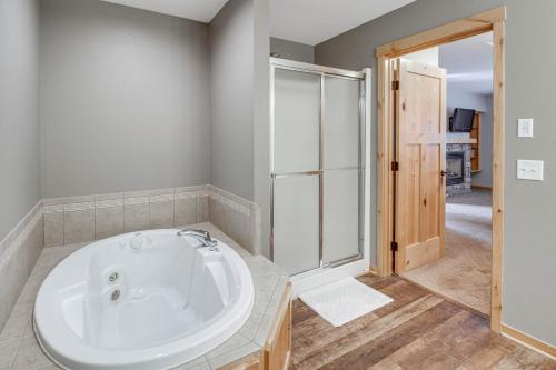 a bathroom with a white tub and a shower at Nisswa Townhome with Boat Slip and Gull Lake Access! in Nisswa