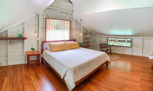 a bedroom with a bed and wooden floors and a window at The Lodge at Punta Rica- Hilltop Eco-Lodge with Views & Pool in Bastimentos