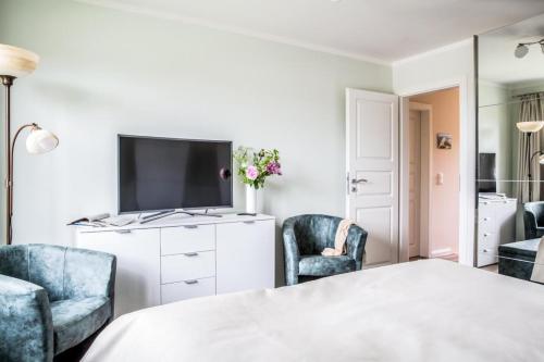 een woonkamer met een tv en 2 stoelen bij Haus Rose, Luxus-Ferienhaus in Fuhlendorf fur 4 Personen in Fuhlendorf