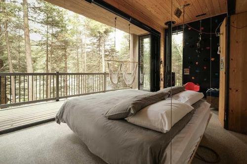 ein großes Bett in einem Schlafzimmer mit einem großen Fenster in der Unterkunft Cabin Zoobox 82 in Eastman
