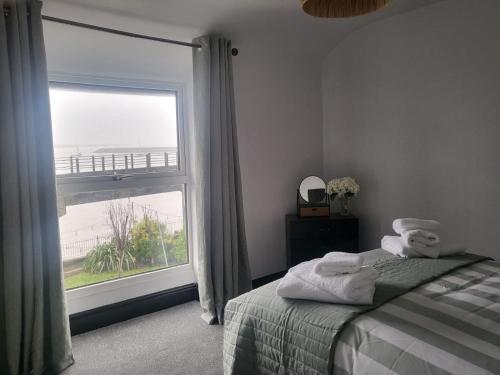 a bedroom with a bed and a large window at Ger y mor in Barmouth