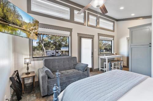 a bedroom with a bed and a couch and windows at 7A Ranch in Wimberley