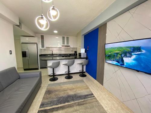 RES. CORAL في بورلامار: غرفة معيشة مع أريكة ومطبخ مع تلفزيون