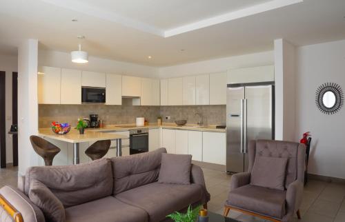 a living room with a couch and a kitchen at Luxurious 2 Bedroom The Edge Labone in Accra