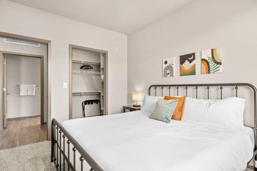 - une chambre avec un grand lit blanc et des oreillers orange dans l'établissement Stunning Westgate CozySuites by stadium with pool 5, à Glendale