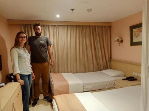 un hombre y una mujer de pie en una habitación de hotel en 2 nights cruise aswan to luxor, en Asuán