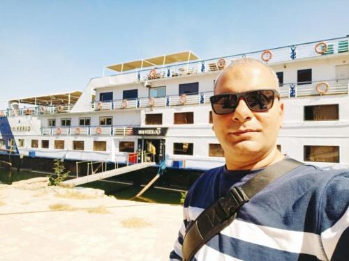 człowiek stojący przed statkiem wycieczkowym w obiekcie 2 nights cruise aswan to luxor w mieście Aswan