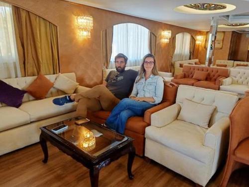 mężczyzna i kobieta siedzący na kanapie w salonie w obiekcie 2 nights cruise aswan to luxor w mieście Aswan