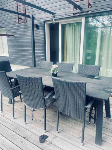 a wooden table and chairs on a patio at Beautiful house in peaceful area in Vantaa